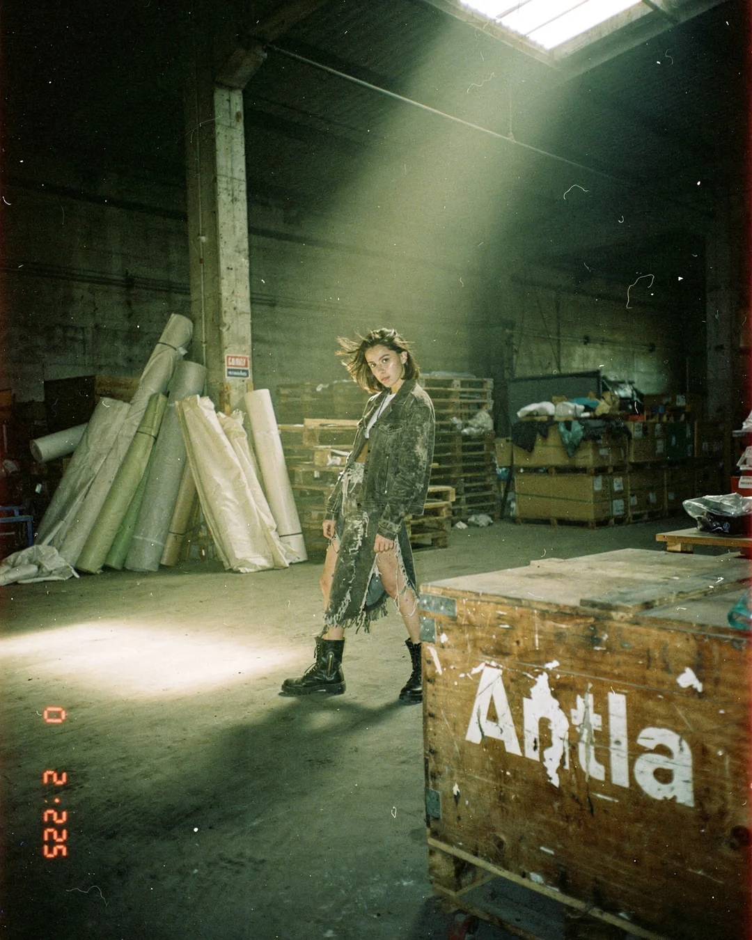 Industrial warehouse fashion editorial with fabric rolls and shipping crates, representing a Shopify fashion returns-reduction strategy