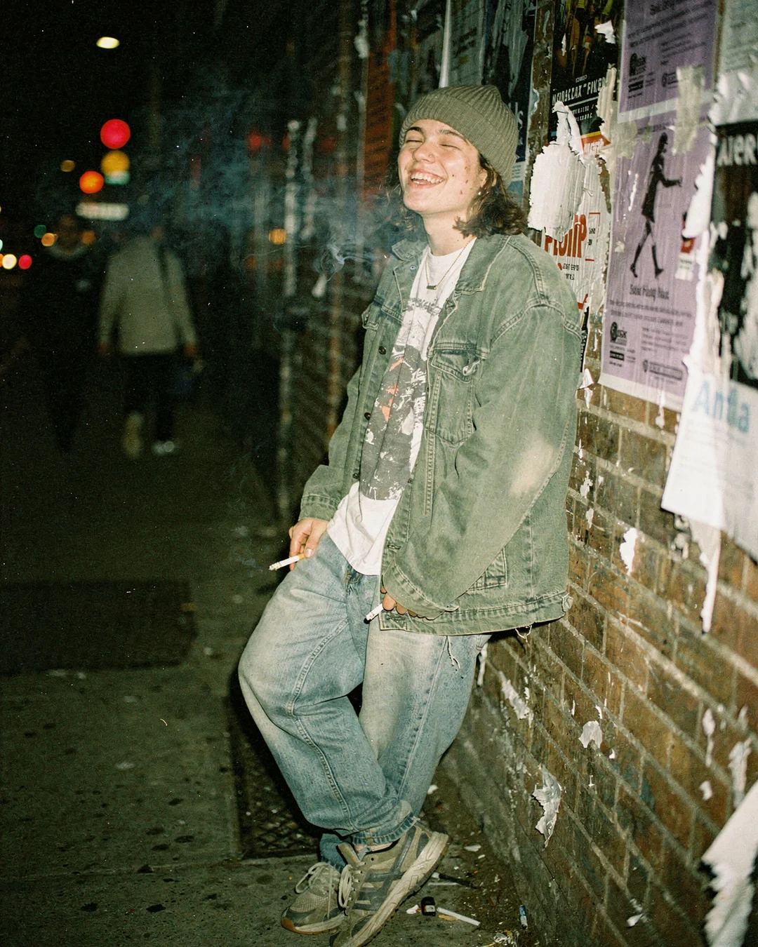 Disposable-camera street fashion photo of a shopper in layered thrift clothing against a brick wall, representing Shopify fashion PDP conversion and product clarity