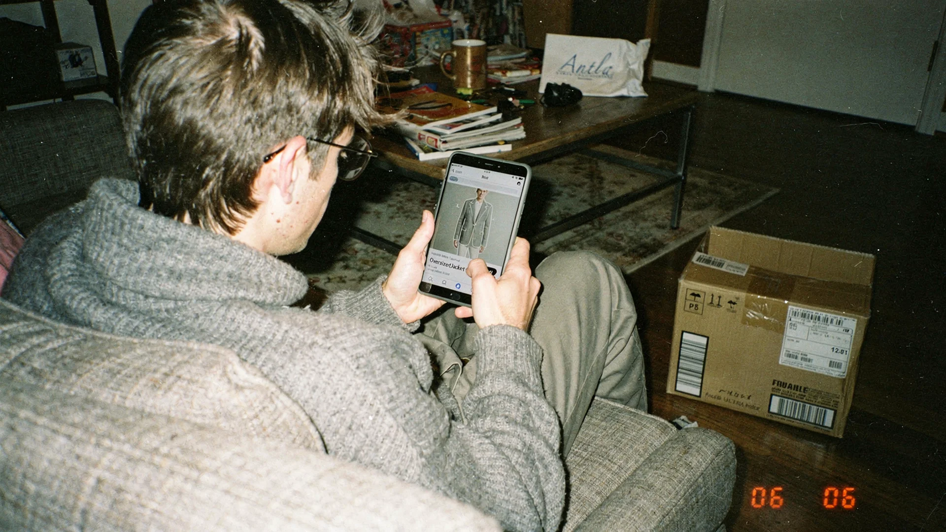 Over-shoulder view of shopper scrolling fashion ecommerce with AI try-on overlay on phone screen