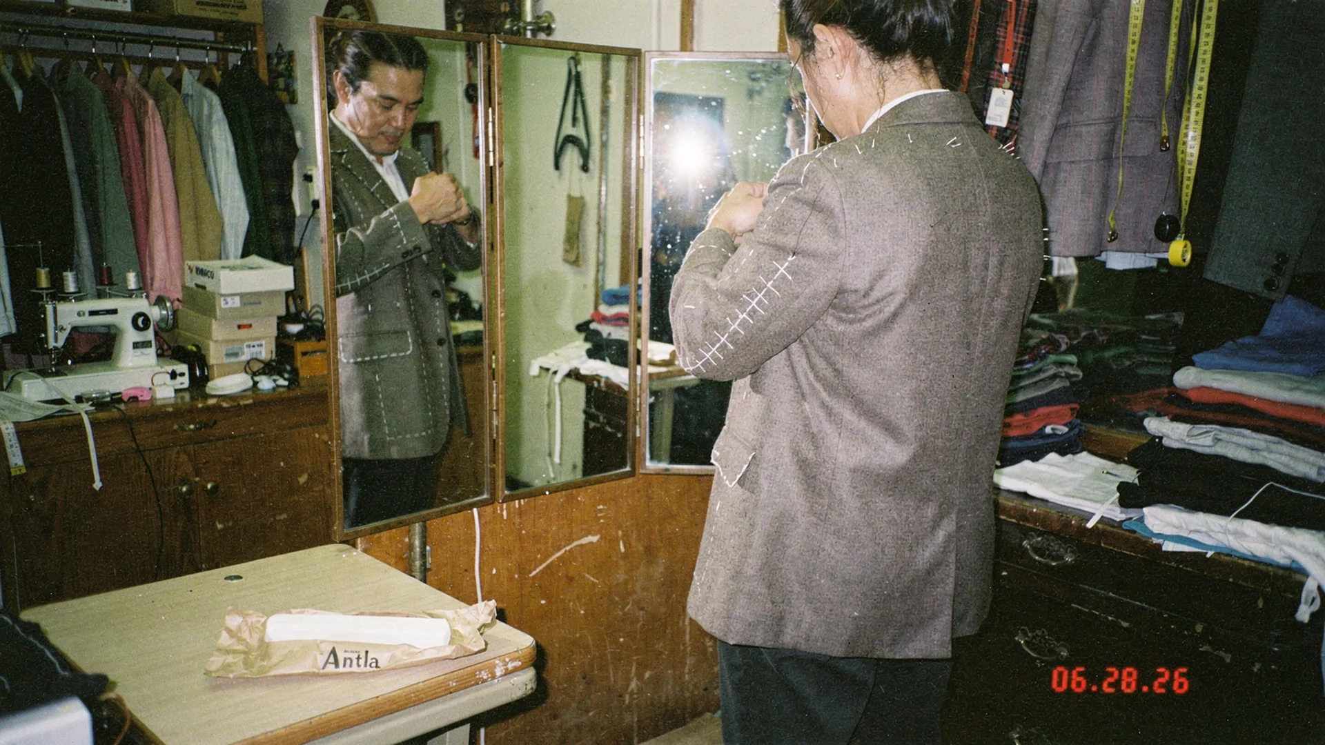 Tailor shop mirror checking structured blazer shoulder seam and lapel line