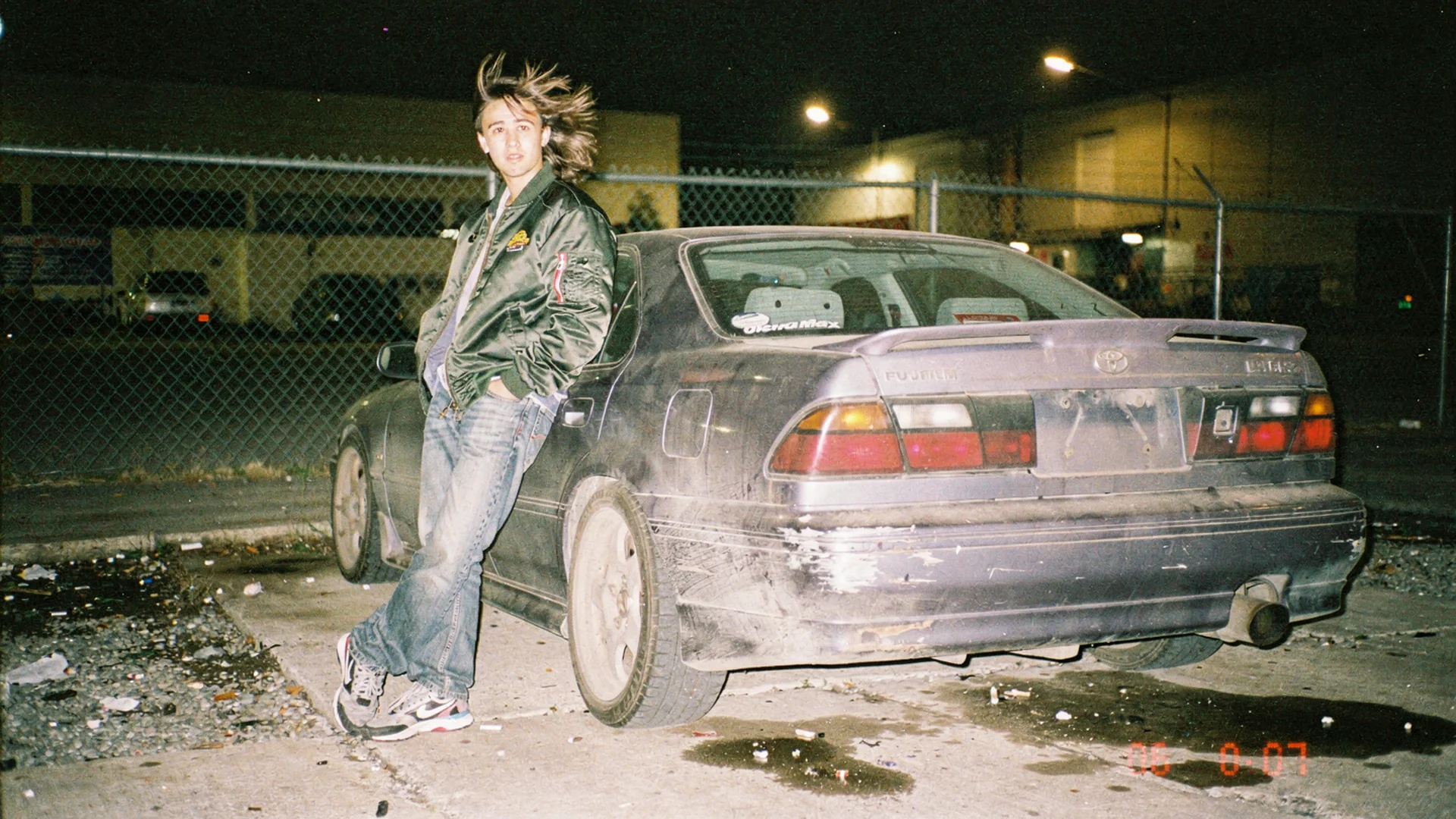 Car enthusiast previewing an aftermarket rear spoiler on their vehicle photo using virtual try-on on a Shopify body kit product page