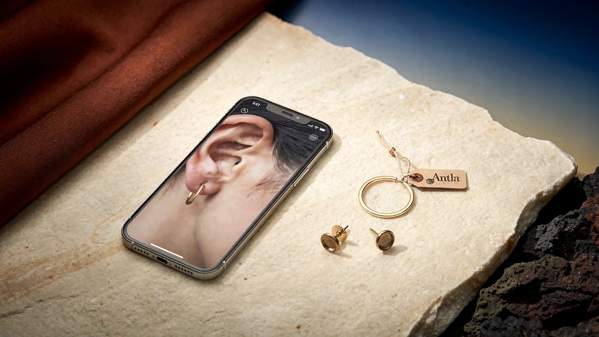 Side by side virtual try-on preview comparing small stud earrings and medium hoop earrings on a shopper's face