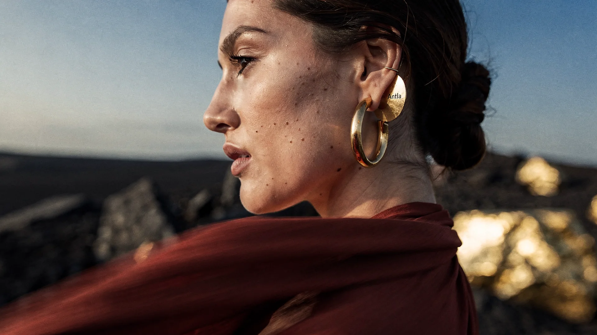Shopper previewing drop earrings on their ears with virtual try-on on a Shopify fine jewelry product page