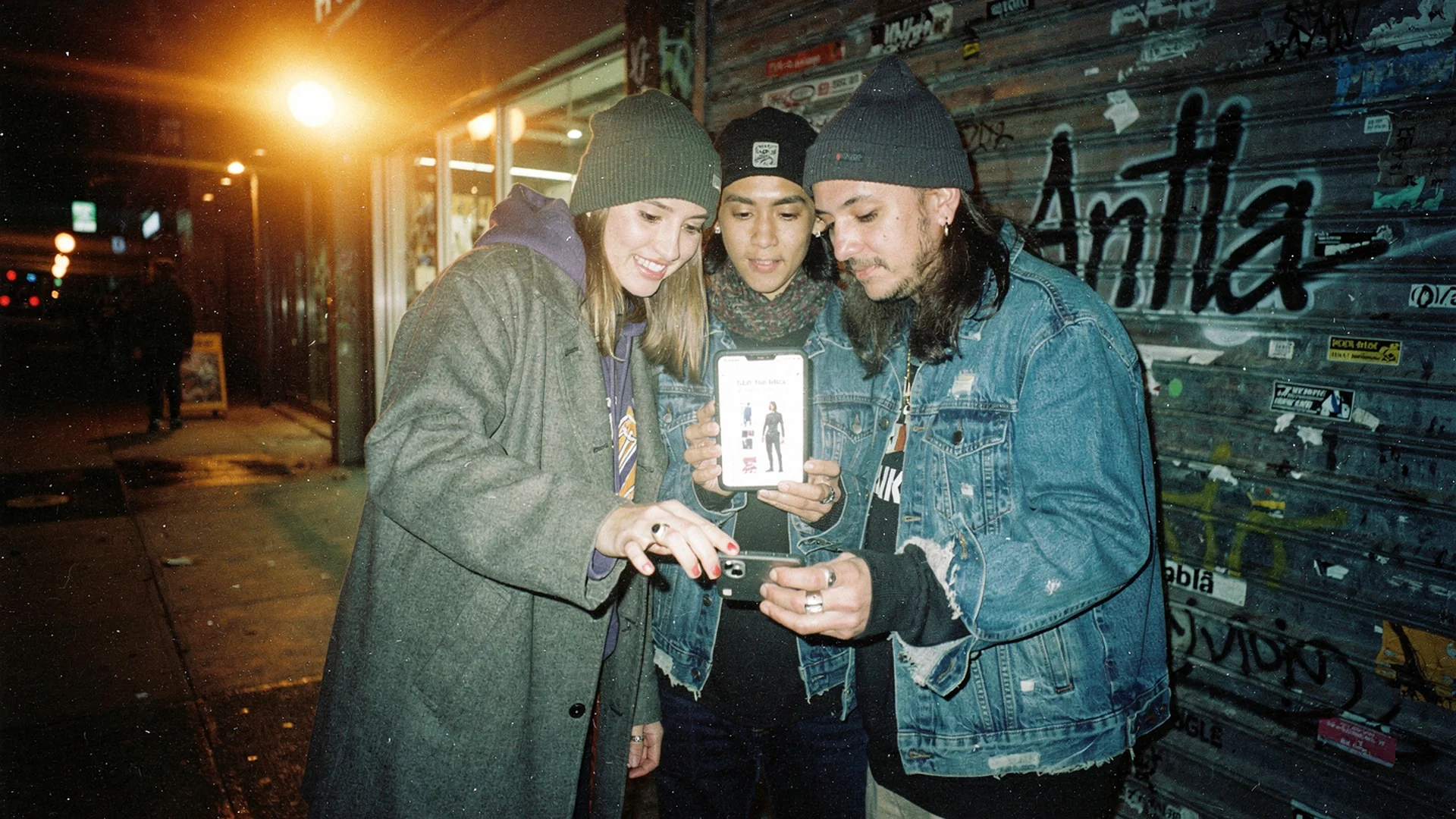Disposable-camera style photo of a fashion studio rail tagged with pre-order sample tickets before a Shopify drop launch